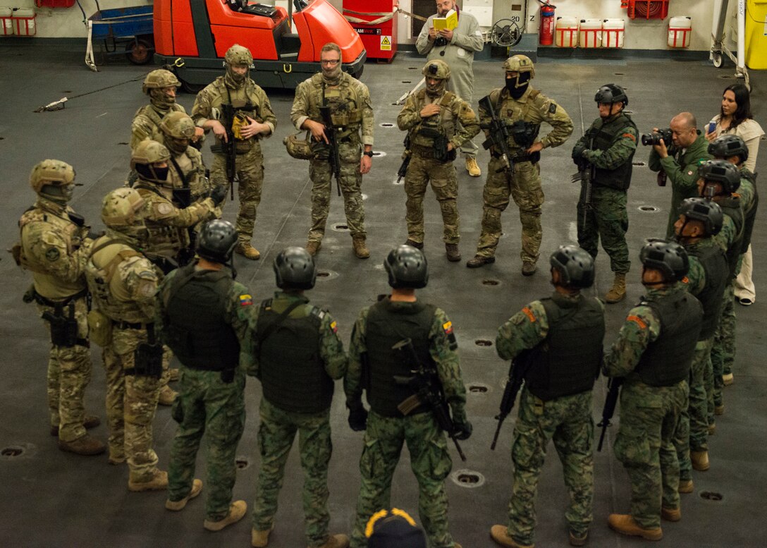 Military personnel gather in a group for a briefing.