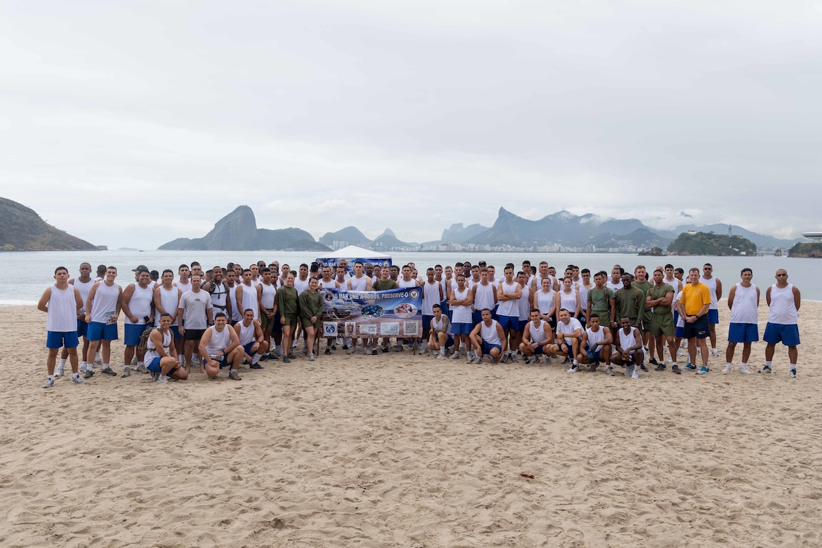 A group of people pose for a picture on the beach.