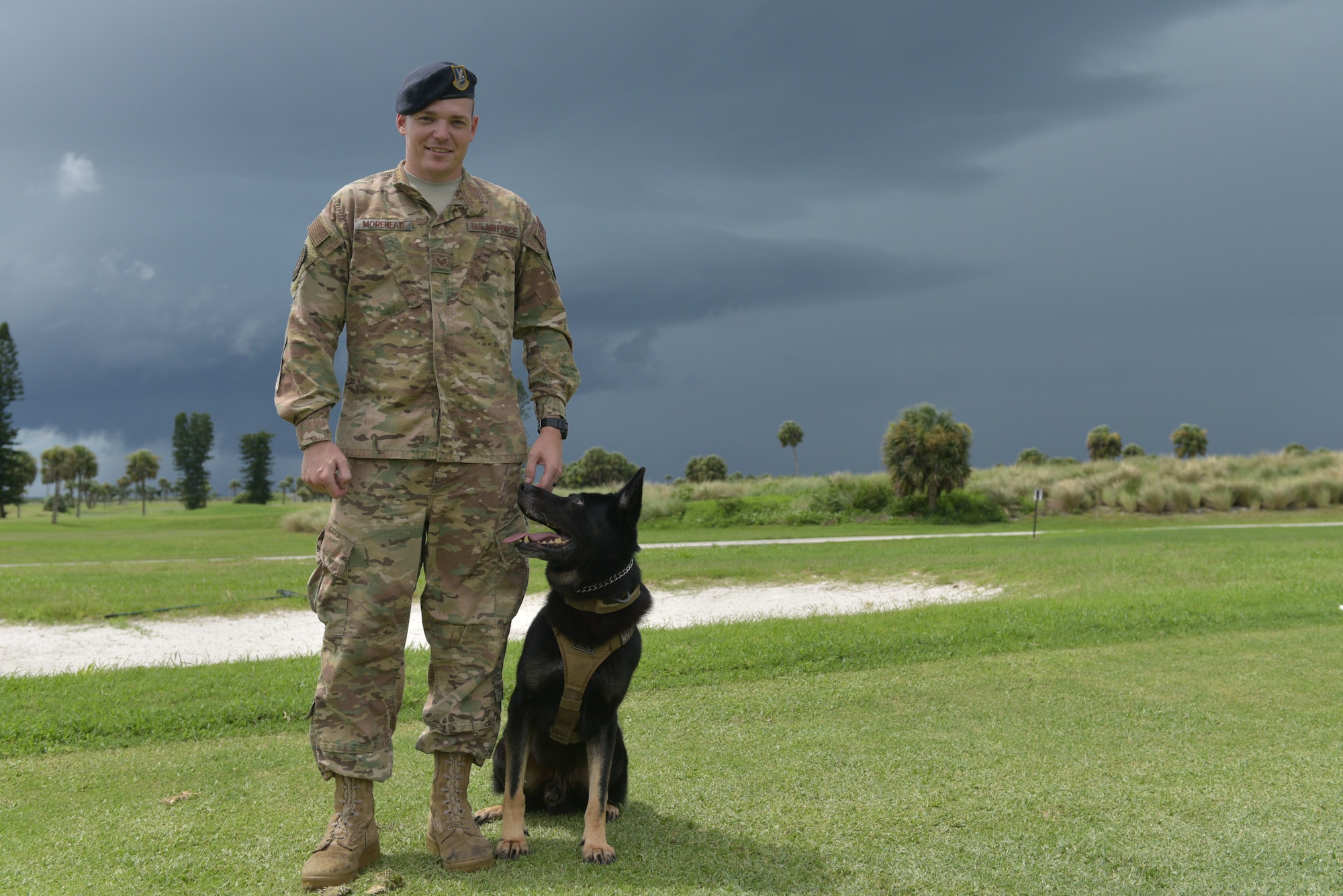 Staff Sgt. Avery Morehead, 45th Security Forces Squadron military working dog handler, and Military Working Dog, Tigi, pose for a photo at Patrick Air Force Base, Fla., August 6, 2019. Morehead was awarded the Life Saving Medal during the Melbourne Regional Chamber Valor Awards for his actions responding to a call at the Patrick AFB golf course. (U.S. Air Force photo by Airman 1st Class Dalton Williams)