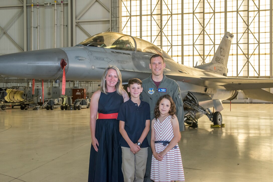 Family of Col. Timothy J. Spaulding gather to take a photo in front of the F16 now with Col. Spaulding's name on it during the change of command ceremony.