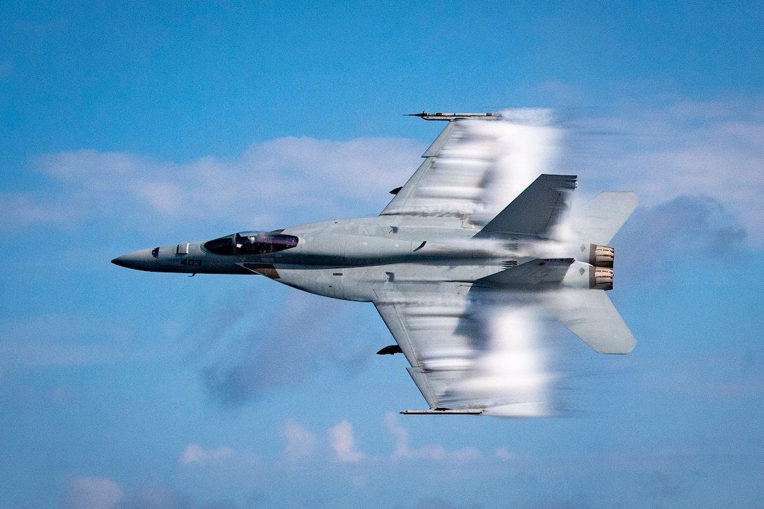 An aircraft flies in the sky at supersonic speeds.