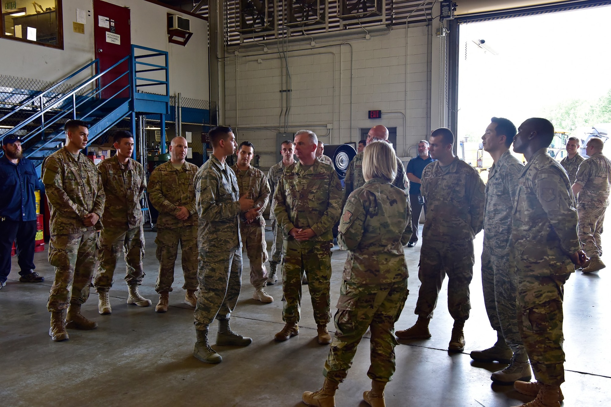Air Force District of Washington Commander Maj. Gen. Ricky N. Rupp and AFDW Command Chief Master Sgt. Christopher Yevchak chat with Airmen from the 11th Logistics Readiness Squadron vehicle maintenace team Aug. 20. Rupp is visiting various units to better learn their missions and meet the people who accomplish them.