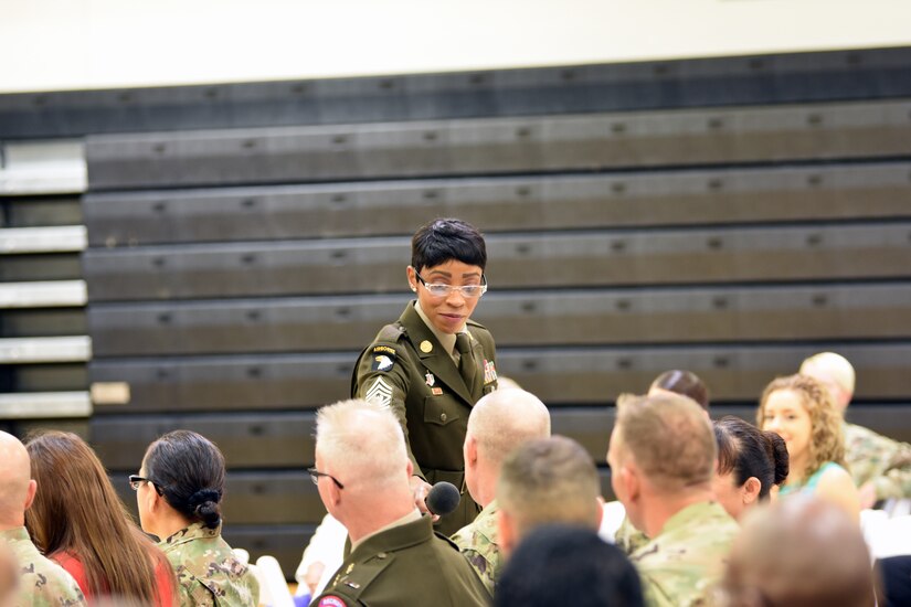 Command Sgt. Maj. Tabitha Gavia, command sergeant major of U.S. Army Recruiting Command and guest speaker, holds the microphone for an audience member to share his ideas for why a young woman should consider Army service during the Fort Knox Women's Equality Day Observance held at Sadowski Center on Fort Knox, Kentucky, Aug. 23.