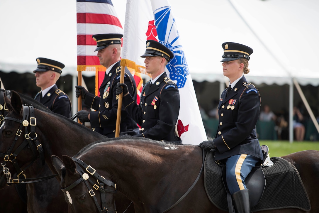 Four soldiers sit on horseback.