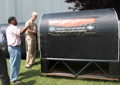 Garry Shields, director of the Disruptive Technologies Lab at Naval Surface Warfare Center, Carderock Division, shows the Optionally Manned Technology Demonstrator to Capt. Pete Small, head of Naval Sea Systems Command’s Unmanned Maritime Systems (PMS 406), during his visit to Carderock’s West Bethesda, Md., site on Aug. 16, 2019. Small was at Carderock to get an overview of Carderock’s unmanned portfolio and capabilities. (U.S. Navy photo by James Contreras/Released)