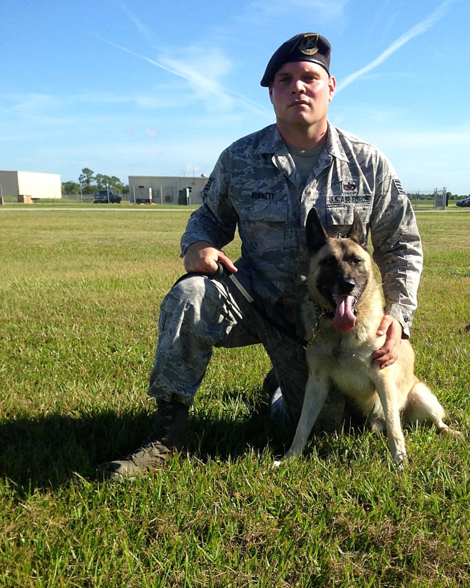 Josh Burnett, a former U.S. Air Force Staff Sgt. and 6th Security Forces military working dog (MWD) handler, poses for a photo with his partner Jecky MWD, Dec. 22, 2014, at MacDill Air Force Base, Fla.  Burnett was Jecky’s handler for 3 years while stationed at MacDill and adopted Jecky following his retirement May 28, 2019.  (Courtesy photo)