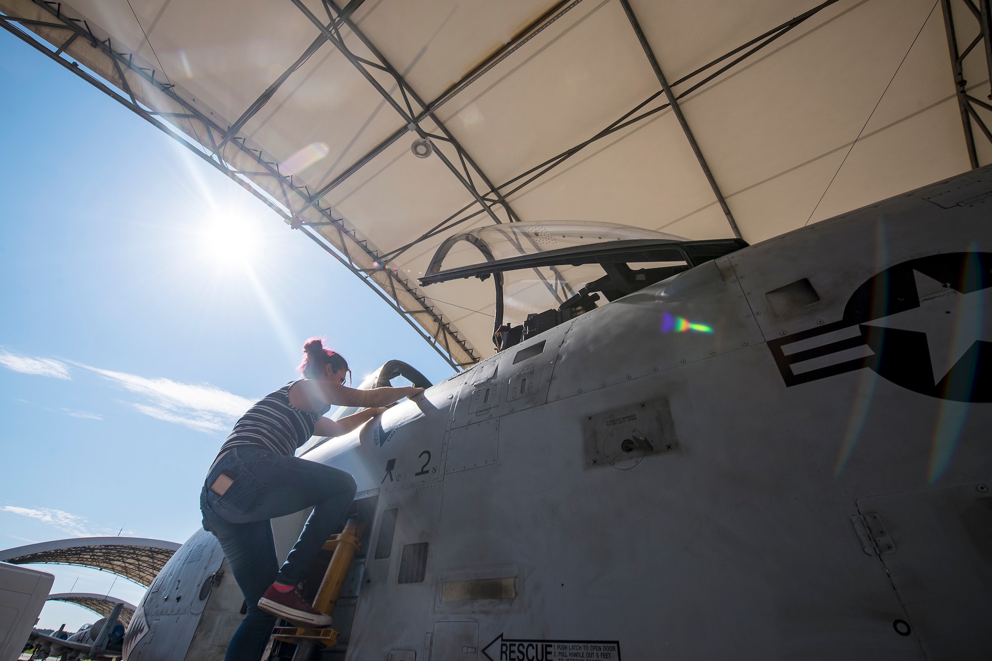 A Team Moody spouse climbs into the cockpit of an A-10C Thunderbolt II Aug. 23, 2019, at Moody Air Force Base, Ga. Spouses and family members from the 23d Aircraft Maintenance Squadron toured the squadron and flightline to gain a first-hand understanding of what role their significant other plays in the mission. The tour also served as a way to expand support networks by connecting spouses and family members with unit personnel. (U.S. Air Force photo by Airman 1st Class Eugene Oliver)