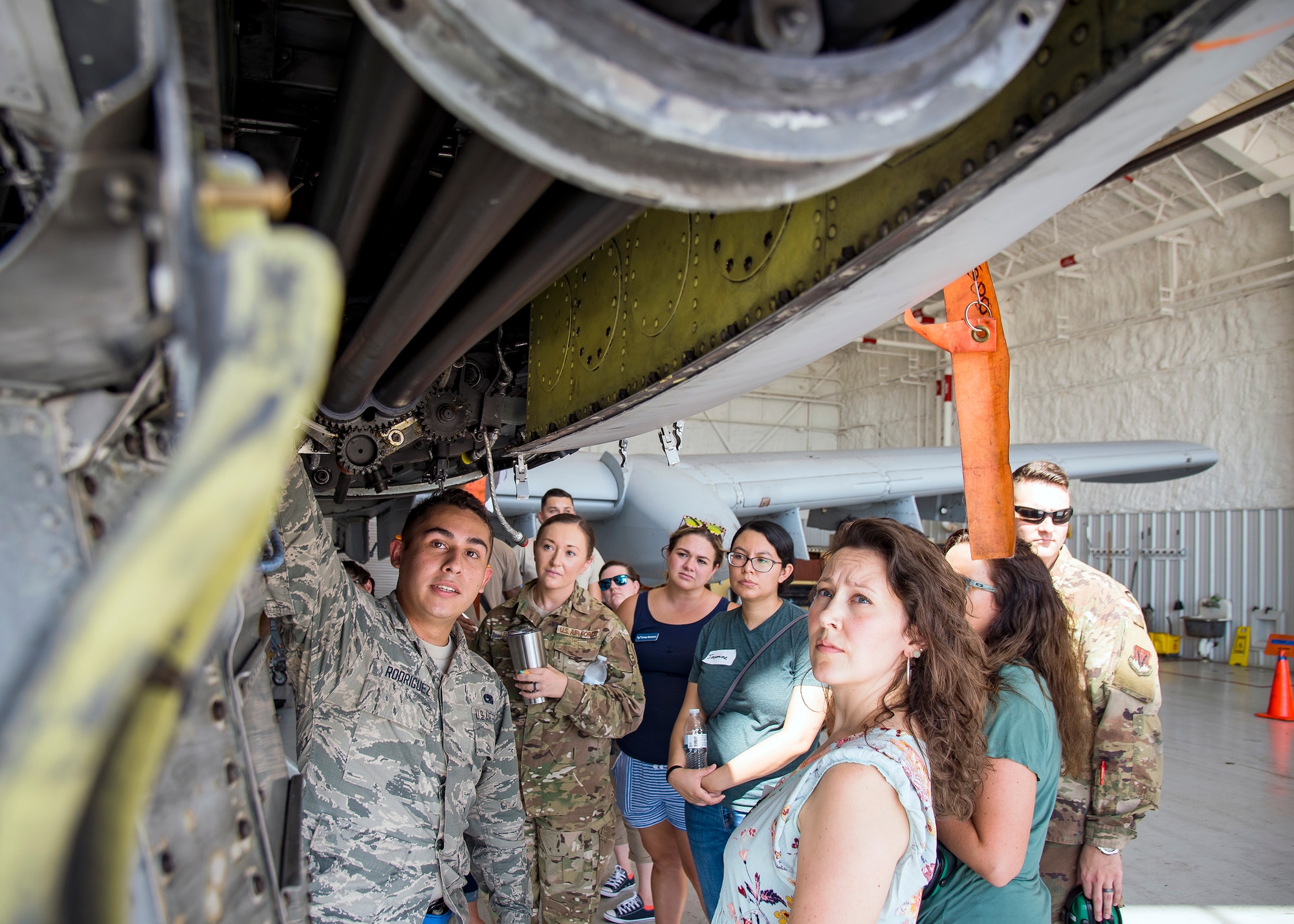 An Airman from the 23d Aircraft Maintenance Squadron (AMXS) left, explains the weapons system of an A-10C Thunderbolt II to Team Moody spouses and family members Aug. 23, 2019, at Moody Air Force Base, Ga. Spouses and family members from the 23d AMXS toured the squadron and flightline to gain a first-hand understanding of what role their significant other plays in the mission. The tour also served as a way to expand support networks by connecting spouses and family members with unit personnel. (U.S. Air Force photo by Airman 1st Class Eugene Oliver)