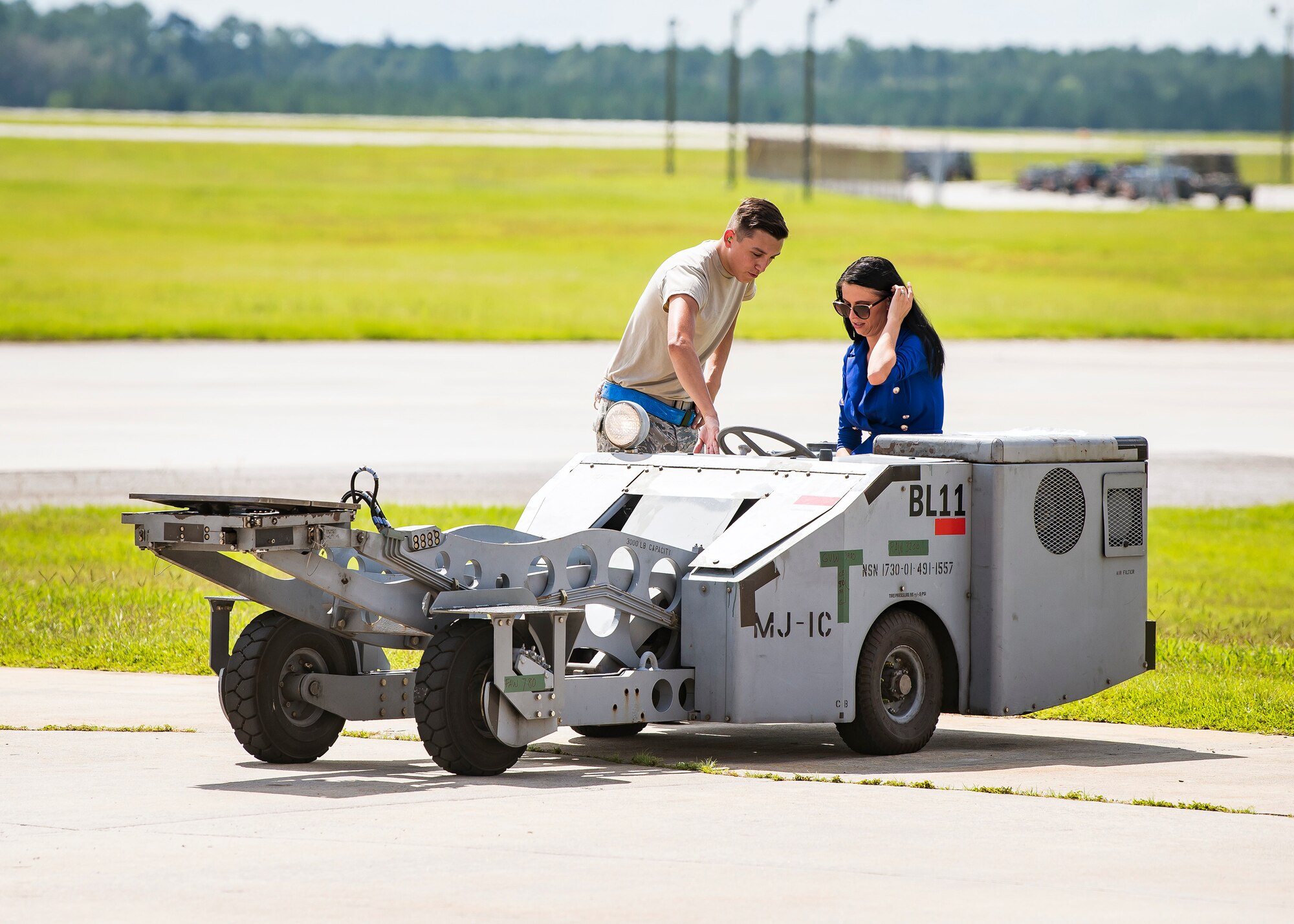 An Airman from the 23d Aircraft Maintenance Squadron (AMXS), left, gives instruction on how to operate a MJ1-B munition handler Aug. 23, 2019, at Moody Air Force Base, Ga. Spouses and family members from the 23d AMXS toured the squadron and flightline to gain a first-hand understanding of what role their significant other plays in the mission. The tour also served as a way to expand support networks by connecting spouses and family members with unit personnel. (U.S. Air Force photo by Airman 1st Class Eugene Oliver)