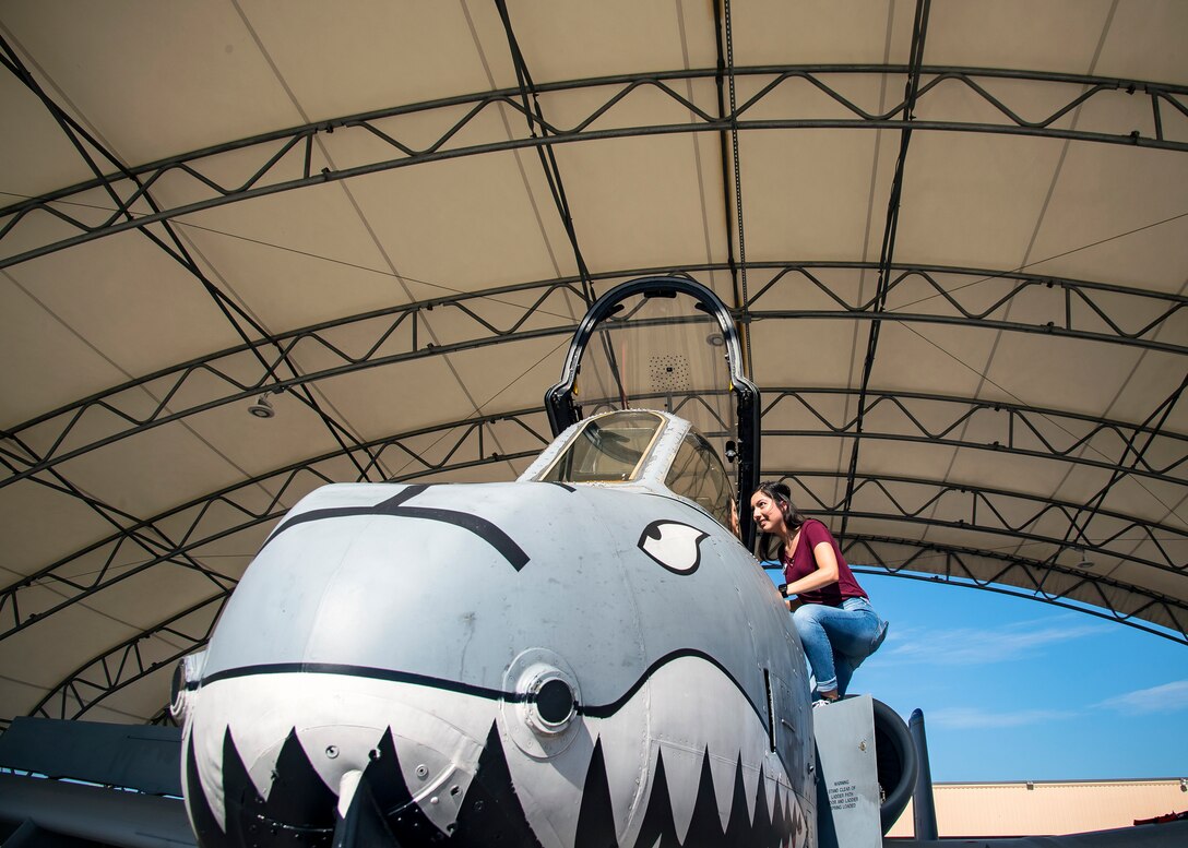 A Team Moody spouse climbs into the cockpit of an A-10C Thunderbolt II Aug. 23, 2019, at Moody Air Force Base, Ga. Spouses and family members from the 23d Aircraft Maintenance Squadron toured the squadron and flightline to gain a first-hand understanding of what role their significant other plays in the mission. The tour also served as a way to expand support networks by connecting spouses and family members with unit personnel. (U.S. Air Force photo by Airman 1st Class Eugene Oliver)