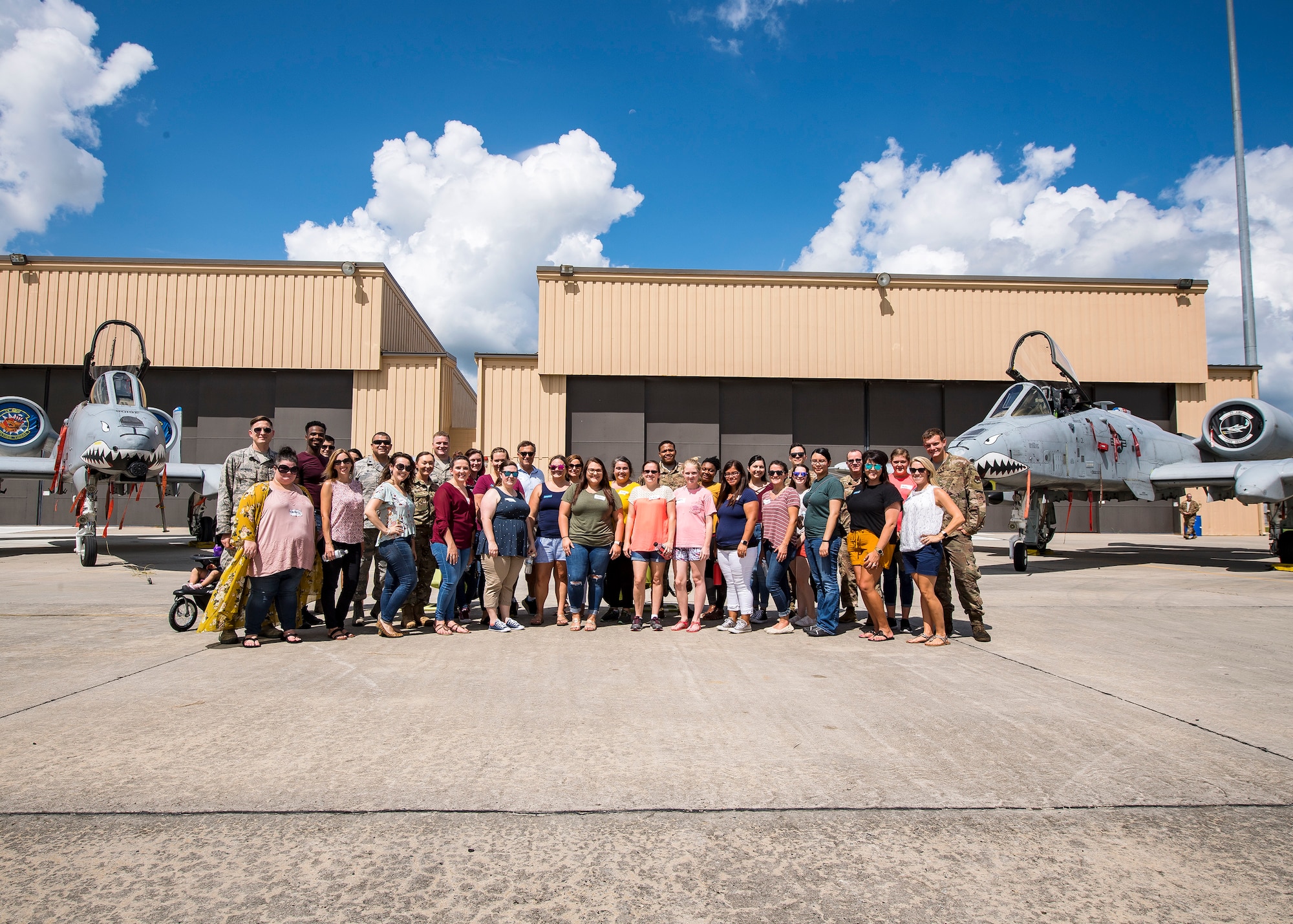 Airmen and Family Members from the 23d Aircraft Maintenance Squadron (AMXS), pose for a picture Aug. 23, 2019, at Moody Air Force Base, Ga. Spouses and family members from the 23d AMXS toured the squadron and flightline to gain a first-hand understanding of what role their significant other plays in the mission. The tour also served as a way to expand support networks by connecting spouses and family members with unit personnel. (U.S. Air Force photo by Airman 1st Class Eugene Oliver)