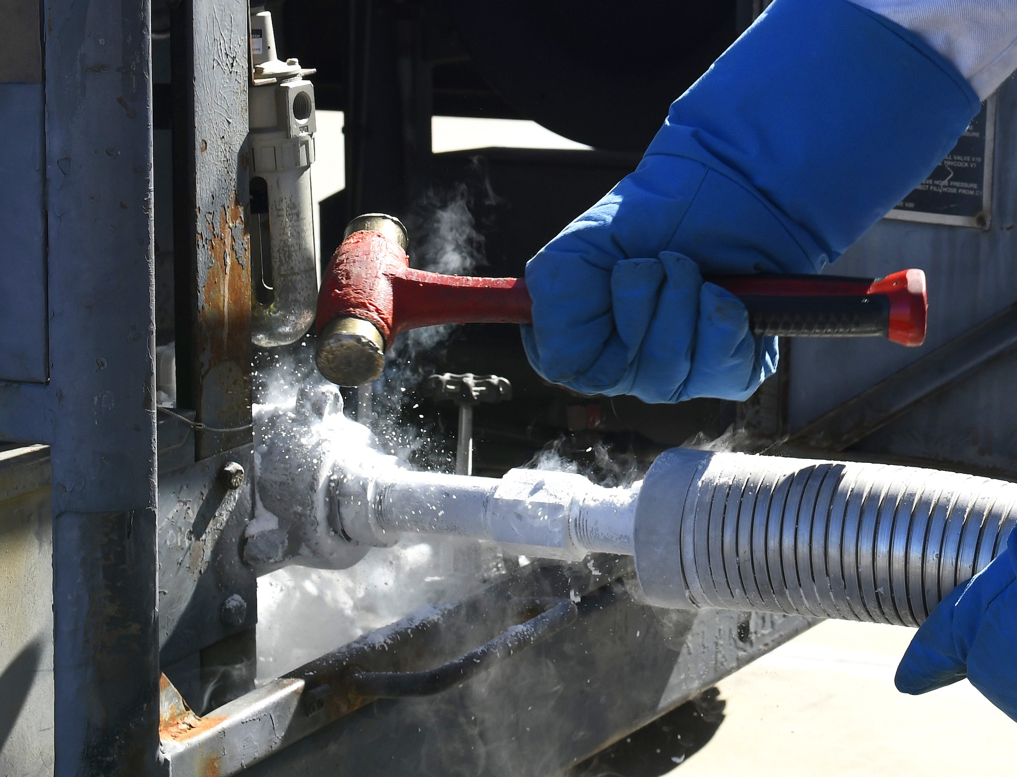 Airman 1st Class Katlynn Masnyk, 56th Logistics Readiness Squadron fuels distribution operator, uses a hammer to loosen a pipe attached to a liquid nitrogen (LIN) cart Aug. 21, 2019, at Luke Air Force Base, Ariz.