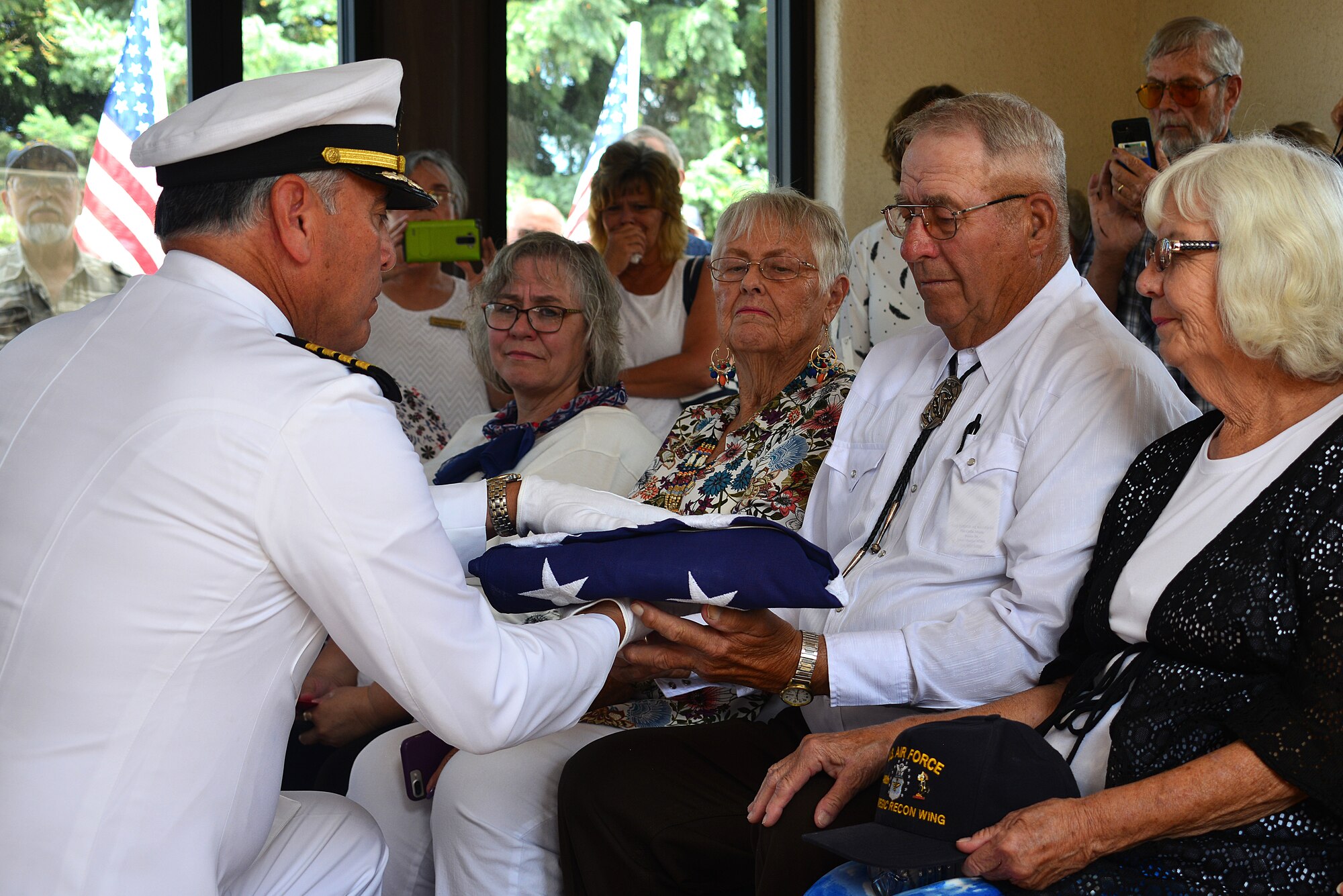 U.S. Navy Capt. Joseph Quintana, Navy Operational Support Center Albuquerque, presents a flag to Jerry Clark, nephew of U.S. Navy Fireman First Class Billy James Johnson, at the Santa Fe National Cemetery in Santa Fe, N.M. Aug. 19, 2019. Technological advances with mitochondrial DNA allowed his primary next of kin to provide a DNA sample which lead to positive identification of his uncle. Of the 429 Sailors that lost their lives on the USS Oklahoma during the attack on Pearl Harbor Dec. 7, 1941, only 35 were later positively identified with this advance technology. (U.S. Air Force photo by Airman 1st Class Austin J. Prisbrey)
