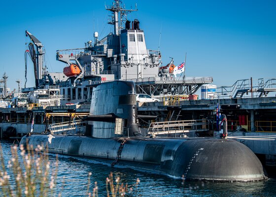 A Collins-class guided missile submarine is moored pier-side during daylight