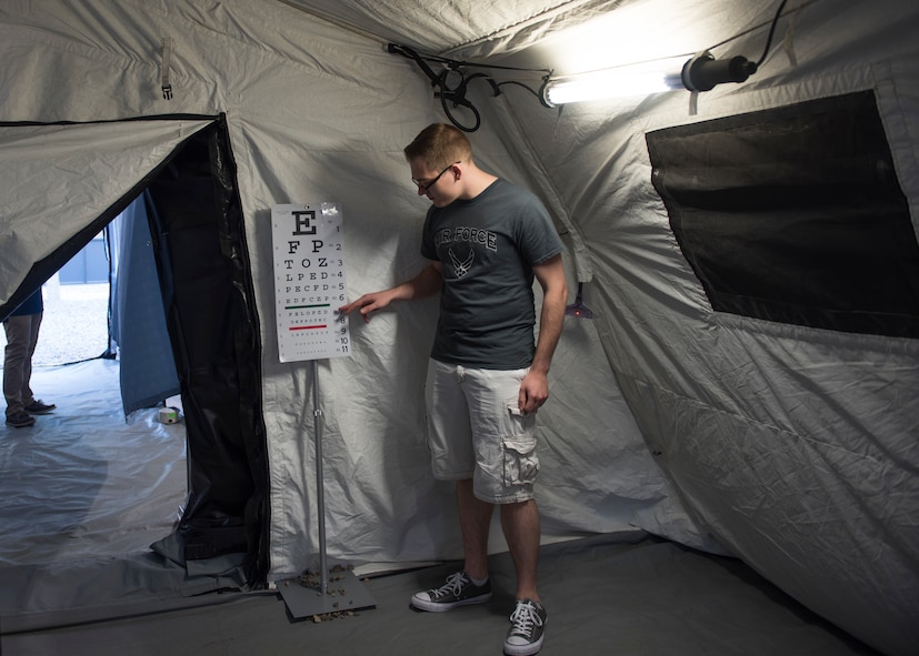 U.S. Air Force Staff Sgt. Daniel Jeppesen, 366th Healthcare Operations Squadron pediatric technician, points to a vision chart August 17, 2019, on Mountain Home Air Force Base, Idaho. Airmen and families were welcomed into the Air Transportable Clinic to recieve free medical physicals. (U.S. Air Force photo by Airman Natalie Rubenak)