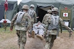 Virginia National Guard Soldiers assigned to the Charlottesville-based Charlie Company, 429th Brigade Support Battalion, 116th Infantry Regiment, 116th Infantry Brigade Combat Team conduct a mass casualty exercise using personnel with simulated injuries July 17, 2019, during eXportable Combat Training Capability Rotation 19-4 at Fort Pickett, Virginia.