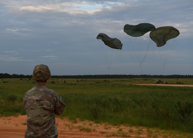 A U.S. Army Soldier assigned to the 82nd Airborne Division monitors equipment being airdropped onto a landing zone during Battalion Mobility Tactical Week at Fort Bragg, N.C., Aug. 20, 2019. Battalion Mass Tactical Week is a joint exercise involving the U.S. Air Force and the U.S. Army designed to enhance service members’ abilities by practicing contingency operations in a controlled environment. The exercise incorporated three C-130J Super Hercules assigned to Little Rock Air Force Base, Arkansas, three C-17 Globemaster IIIs assigned to Joint Base Charleston, S.C. and Army paratroopers assigned to the 82nd Airborne Division of Fort Bragg, N.C. The exercise allowed all parties to quickly and safely complete training tasks, such as personnel and cargo air drops, to prepare joint forces to operate during global mobility missions.