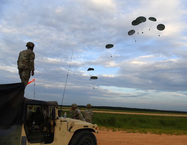 U.S. Army Soldiers assigned to the 82nd Airborne Division monitor equipment being airdropped onto a landing zone by C-17 Globemaster III’s from Joint Base Charleston during Battalion Mobility Tactical Week at Fort Bragg, N.C., Aug. 20, 2019. Battalion Mass Tactical Week is a joint exercise involving the U.S. Air Force and the U.S. Army designed to enhance service members’ abilities by practicing contingency operations in a controlled environment. The exercise incorporated three C-130J Super Hercules assigned to Little Rock Air Force Base, Arkansas, three C-17 Globemaster IIIs assigned to Joint Base Charleston, S.C. and Army paratroopers assigned to the 82nd Airborne Division of Fort Bragg, N.C. The exercise allowed all parties to quickly and safely complete training tasks, such as personnel and cargo air drops, to prepare joint forces to operate during global mobility missions.