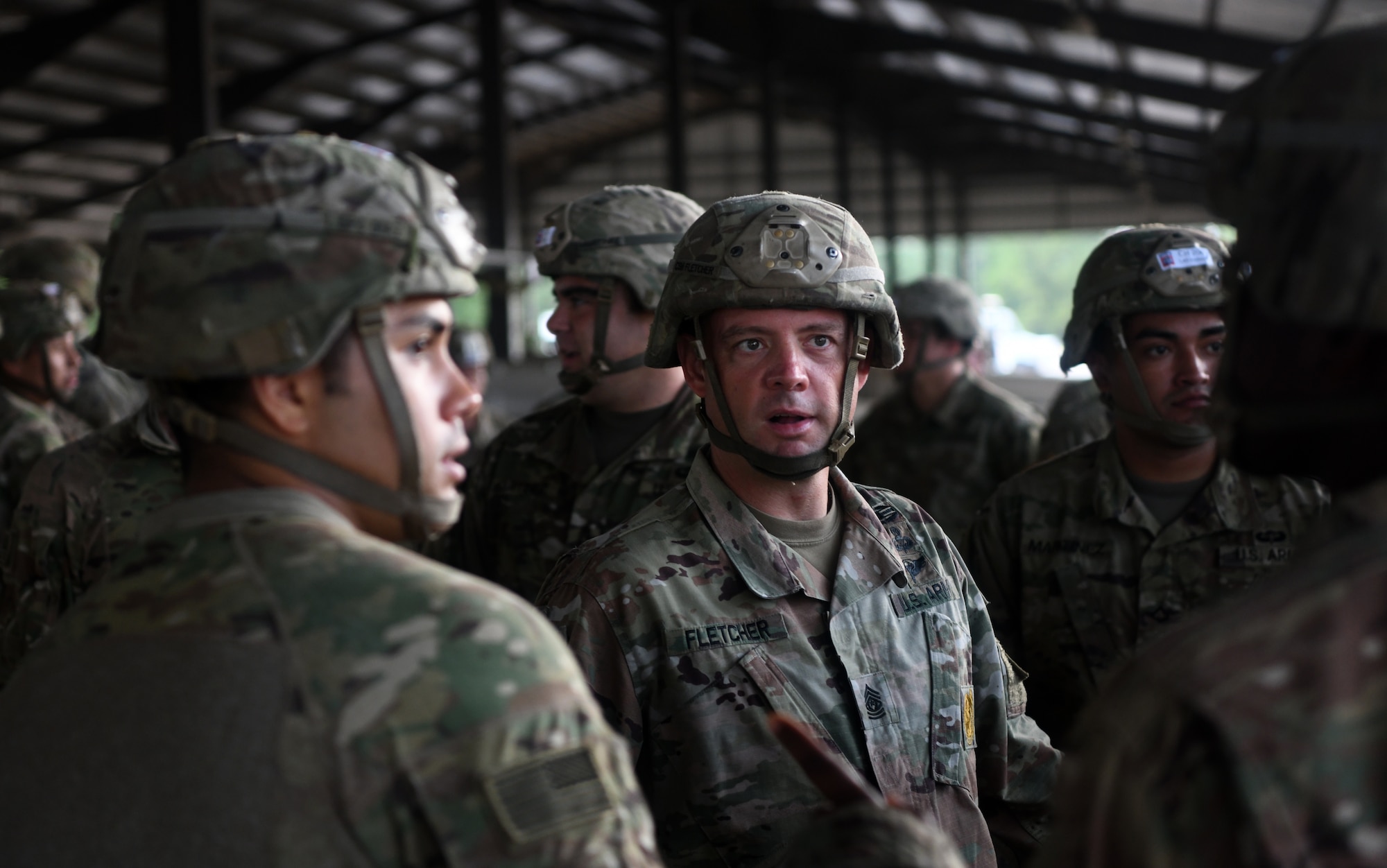 A paratrooper jump master assigned to the 82nd Airborne Division addresses his troops before taking part in fall exercises during Battalion Mobility Tactical Week at Fort Bragg, N.C., Aug. 19, 2019. Battalion Mass Tactical Week is a joint exercise involving the U.S. Air Force and the U.S. Army designed to enhance service members’ abilities by practicing contingency operations in a controlled environment. The exercise incorporated three C-130J Super Hercules assigned to Little Rock Air Force Base, Arkansas, three C-17 Globemaster IIIs assigned to Joint Base Charleston, S.C. and Army paratroopers assigned to the 82nd Airborne Division of Fort Bragg, N.C. The exercise allowed all parties to quickly and safely complete training tasks, such as personnel and cargo air drops, to prepare joint forces to operate during global mobility missions.