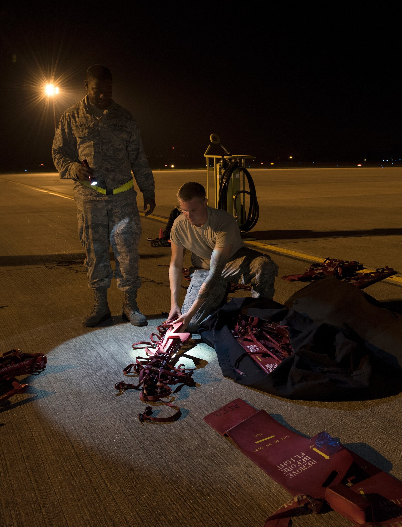 Senior Airman  Markeece Powell and Airman 1st Class Austin Sawchuk, B-2 Spirit crew chiefs assigned to the 509th Bomb Wing at Whiteman Air Force Base, Missouri, prepare covers for a B-2 Spirit after it landed at Royal Air Force Fairford, England, on Aug. 27, 2019. The Bomber Task Force deployment of the stealth bomber aircraft, Airmen and support equipment arrived in the U.S. European Command area of operations for a deployment to conduct theater integration and flying training. The deployment of strategic bombers to the United Kingdom helps exercise RAF Fairford as a forward operating base for the unit, ensuring they are engaged, postured and ready with credible force to assure, deter and defend the U.S. and its allies in an increasingly complex security environment. (U.S. Air Force photo by Staff Sgt. Kayla White)