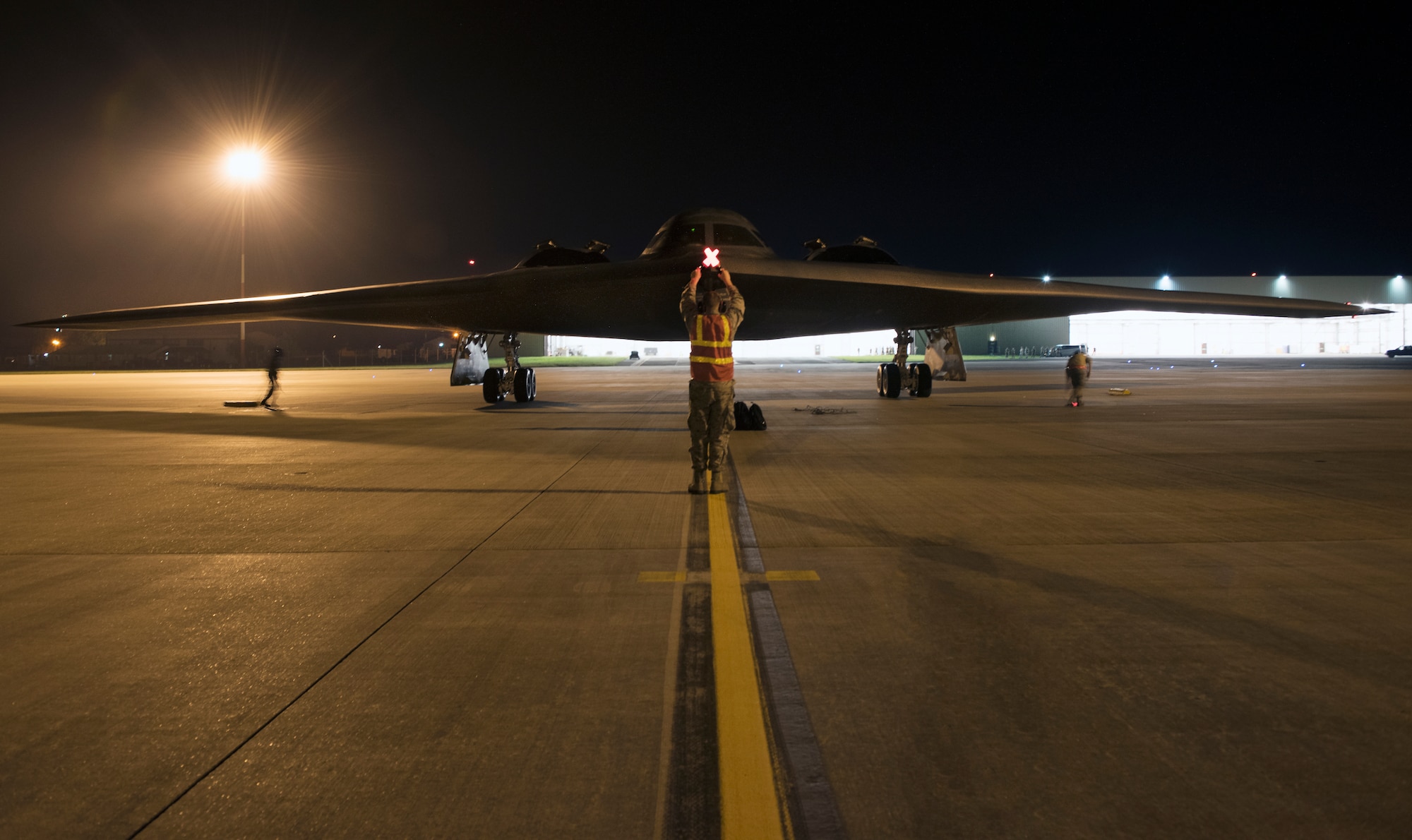 Airman 1st Class Austin Sawchuk, a crew chief assigned to the 509th Bomb Wing, marshals in a B-2 Spirit on the flightline at Royal Air Force Fairford, England, Aug. 27, 2019. A Bomber Task Force deployment of the B-2, Airmen and support equipment from Whiteman AFB arrived in the U.S. European Command area of operations for a deployment to conduct theater integration and flying training. The deployment of strategic bombers to the United Kingdom helps exercise RAF Fairford as a forward operating base for the unit, ensuring they are engaged, postured and ready with credible force to assure, deter and defend the U.S. and its allies in an increasingly complex security environment. (U.S. Air Force photo by Staff Sgt. Kayla White)