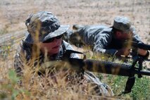 a photo of airmen laying on the ground working with practice M-16s