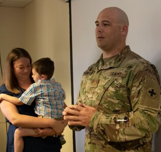 Newly promoted Maj. Shawn Robertson, joined by wife, Sarah, and son, Reid, addresses friends attending his promotion ceremony, Aug. 23.