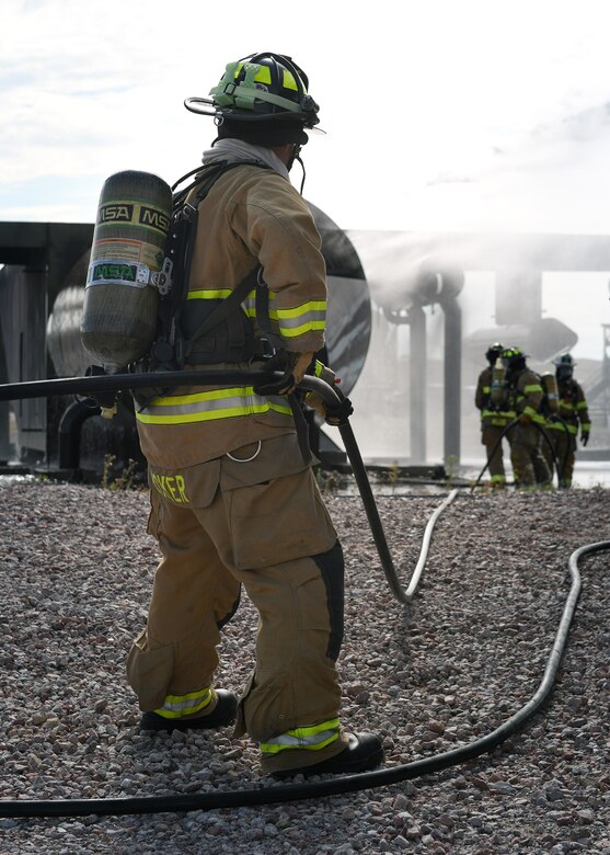 Fire protection Airmen from the 21st Civil Engineer Squadron train for aircraft fire scenarios Aug. 7, 2019, on Peterson Air Force Base, Colorado. The firefighters practiced on a mock aircraft structure that is surrounded by a pool of water. (U.S. Air Force photo by Airman 1st Class Andrew Bertain)