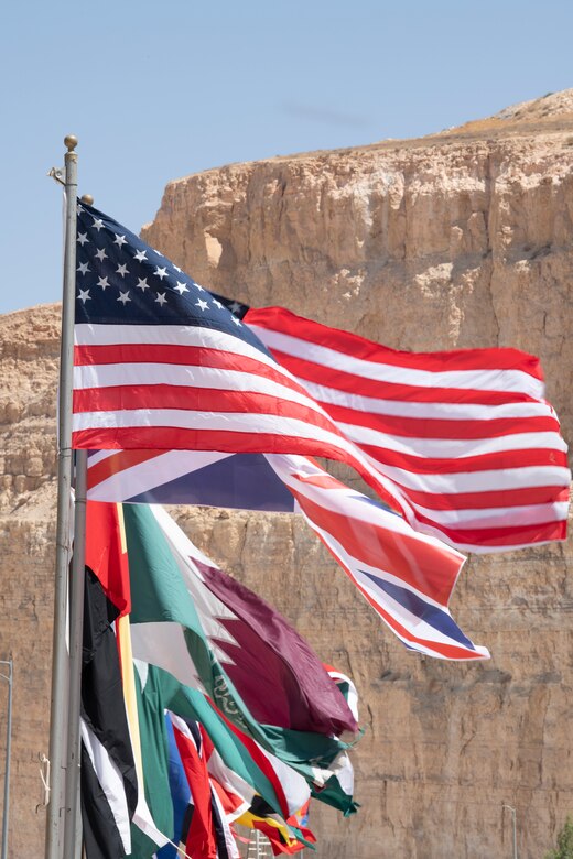 Flags representing the 30 nations from around the world participating in Eager Lion 19, fly over King Abdullah II Special Operations Training Center (KASOTC), Jordan, Aug. 25 2019. Eager Lion 19 is a multilateral exercise hosted by the  Kingdom of Jordan, consisting of a total of 30 nations from around the world, designed to exchange military expertise and improve interoperability among partner nations.