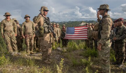 Spc. Eugene Bromberg (left with hand raised), an infantryman, is led in the oath of reenlistment by his commanding officer Army Cpt. Evan Dimakas (right with hand raised) in Poptun, Guatemala, July 15, 2019. The two are flanked by Soldiers from B Company, 182nd Infantry Regiment and Guatemalan Kaiblies. Bromberg, who immediately bonded with the Guatemalan special forces soldiers, asked that they be included in his reenlistment ceremony.