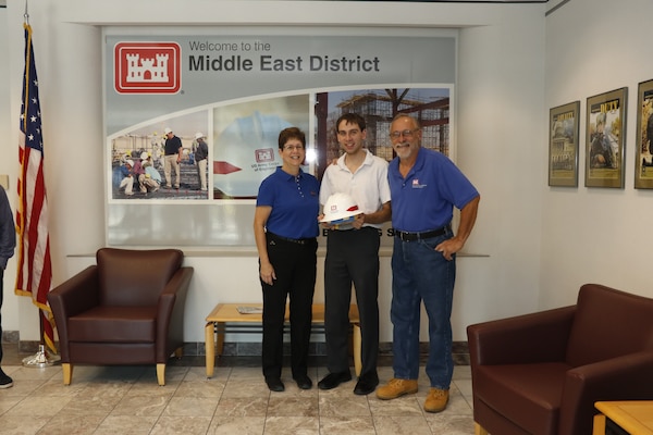 Carol and Bob Hickel, on the outer sides, both ready to go enjoy their retirements, passed the hard hat on to their son David Hickel, who has worked as a summer intern with the Middle East District this year and hopes to finish college and come back permanently.