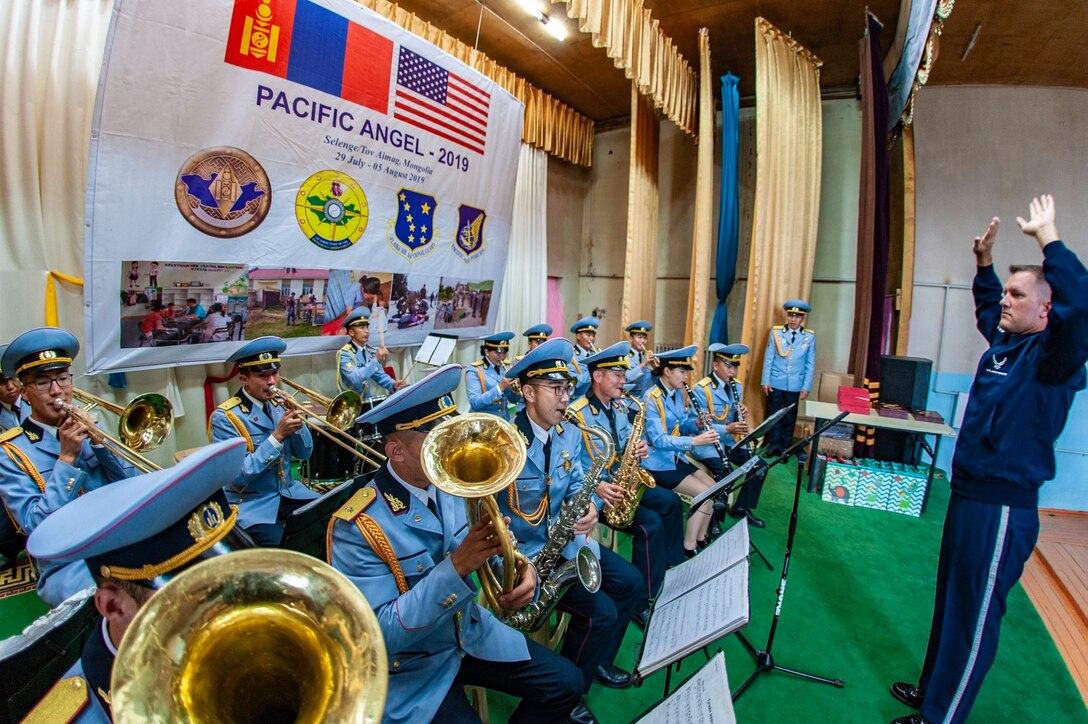 Chief Master Sgt. Stephen Larson, U.S. Air Force Band of the Pacific chief enlisted manager, conducts the American national anthem with members of the Mongolian Armed Forces Band during a recent event in Mongolia. (Courtesy photo)