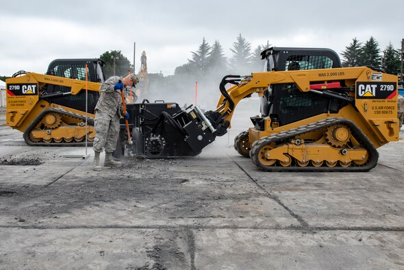 U.S. Air Force and the Japan Air Self-Defense Force (JASDF) civil engineers work together to cut a square around the simulated impact crater as part of rapid airfield damage repair (RADR) operations during Pacific Unity 2019 at Yokota Air Base, Japan, August 22, 2019.