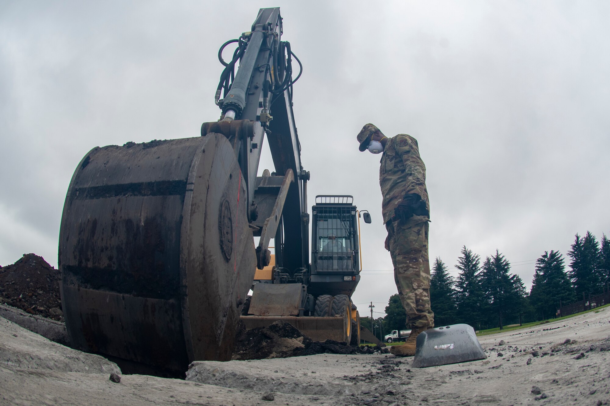 Staff Sgt. Marquette Ricardson, 8th Civil Engineer Squadron dirt boy out of Kunsan Air Base, Republic of Korea, works with a Japan Air Self-Defense Force (JASDF) engineer operating equipment to dig a hole to the proper depth during rapid airfield damage repair (RADR) during Pacific Unity 2019 at Yokota Air Base, Japan, August 22, 2019.