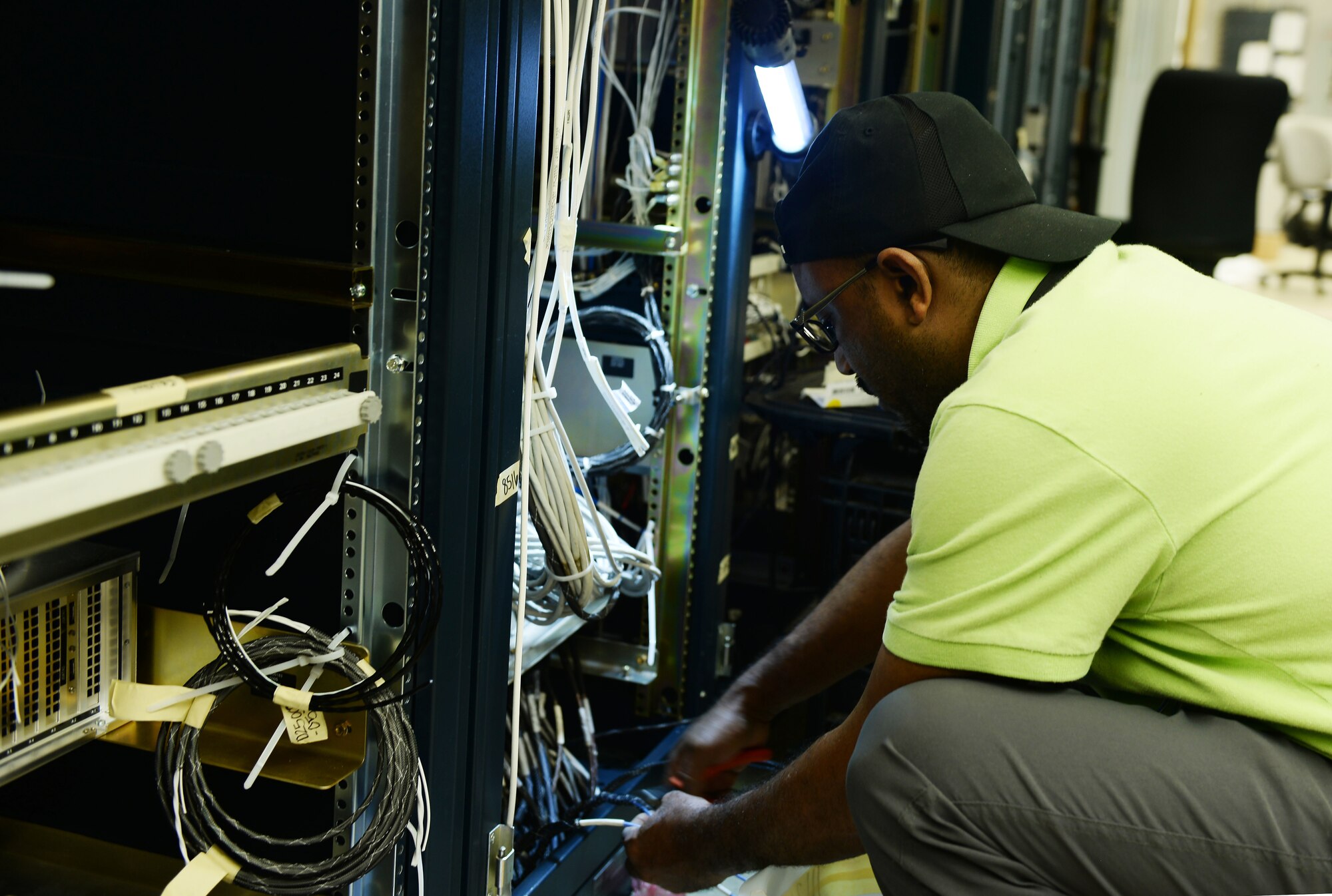 Hamza Mebratie, L3Harris Technologies, cuts wire to install a new simulator Aug. 12, 2019, inside the Martin Bomber building on Offutt Air Force Base, Nebraska. This new simulator is needed in aiding Team Offutt members to perform initial, requalification and continuation training in an organized environment. Additionally the simulator will restore the ability to partake in numerous multi-organizational exercises.