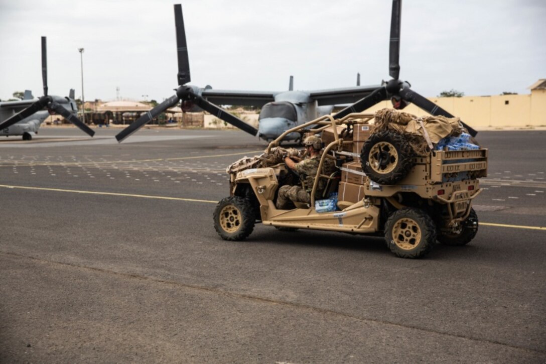 A U.S. Air Force para rescueman with Special Purpose Marine Air-Ground Task Force-Crisis Response-Africa 19.2, Marine Forces Europe and Africa, transports a utility -terrain vehicle on a flight line in Dakar, Senegal, Aug. 6, 2019. SPMAGTF-CR-AF 19.2 rehearsed embassy reinforcement procedures at U.S. Embassy Bamako, Mali. SPMAGTF-CR-AF is deployed to conduct crisis-response and theater-security operations in Africa and promote regional stability by conducting military-to-military training exercises throughout Europe and Africa. (U.S. Marine Corps photo by Cpl. Margaret Gale)