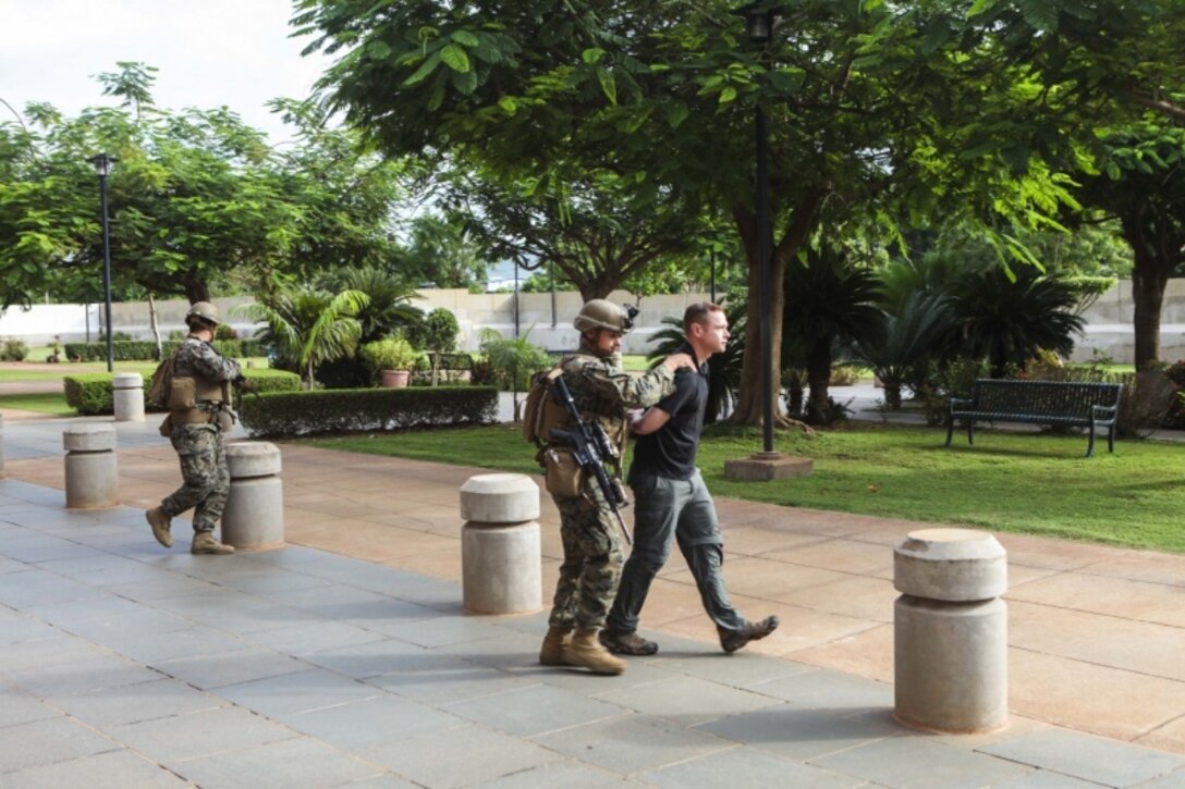 U.S. Marines with Special Purpose Marine Air-Ground Task Force-Crisis-Response-Africa 19.2, Marine Forces Europe and Africa, detain a mock-enemy combatant at during an embassy-reinforcement exercise the U.S. Embassy in Bamako, Mali, Aug. 7, 2019. The Marines responded to a notional-complex enemy attack on the U.S. Embassy and rehearsed securing the embassy compound, safeguarding personnel, and treating simulated casualties. SPMAGTF-CR-AF rehearsed reinforcing the embassy in order to increase proficiency as an alert force and exercise crisis-response operations in support of U.S. interests. (U.S. Marine Corps photo by Cpl. Margaret Gale)