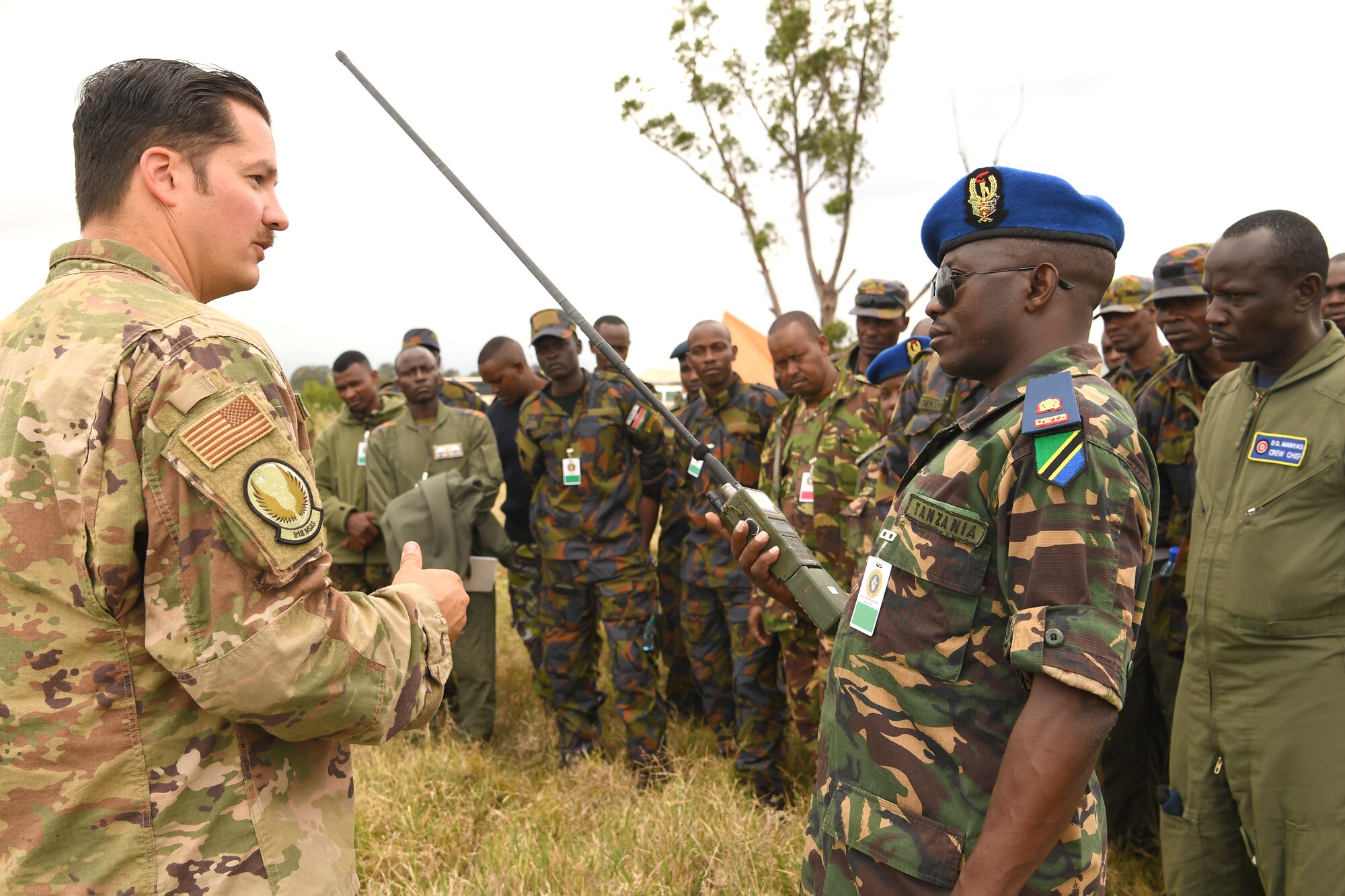 U.S. Air Force Tech. Sgt. Jared Todd, 818th Mobility Support Advisory Squadron Survival, Evasion, Resistance and Escape air advisor, and Tanzania Air Force Command Col. Ian Haule, an aircraft maintenance engineer, discuss radio communication techniques at the African Partnership Flight Kenya 2019, Laikipia Air Base, Kenya, August 22, 2019.