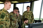 U.S. Air Force Lt. Col. Allen Kao, a public health officer assigned to the 179th Medical Group, answers the phone and works alongside his Hungarian counterparts during a simulated in-flight emergency response exercise Aug. 1, 2019, at Pápa Air Base, Hungary. The simulation was a part of a three-weeklong intermediate airfield management course that an Ohio National Guard mobile training team led for its Hungarian partners. Ohio and Hungary have been paired through the Department of Defense State Partnership Program since 1993.