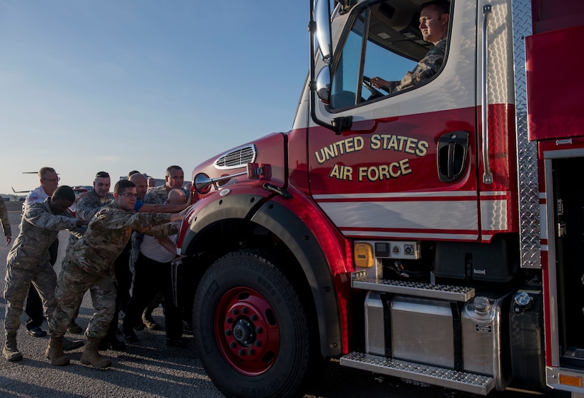 Members of the 628th Civil Engineer Squadron Fire Department push a firetruck during a push-in ceremony at Joint Base Charleston, S.C. Aug. 27, 2019. The push-in ceremony was a way for the Fire Department to welcome two new firetrucks to their fleet, a P-26 water tanker and a P-26 aerial apparatus, and was the first of its kind at JB Charleston. Push-in ceremonies date back to when firefighters responded with horses and carriages and pushed their carriages back into stalls after returning from a call.