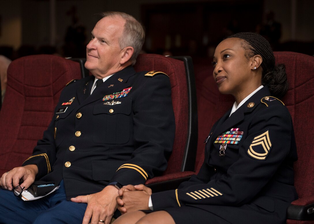 U.S. Army Maj. Jeffrey Ellis, Fort Eustis Regimental Memorial Chapel family life chaplain, and Sgt. 1st Class Patricia Conyers, U.S. Army School of Music vocal instructor, listen to a speech during a Women’s Equality Day observance presentation at Joint Base Langley-Eustis, Virginia, Aug. 27, 2019.