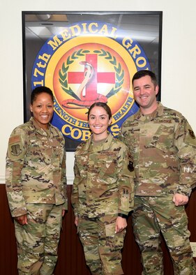 U.S. Air Force Airman 1st Class Breanna Carter, 17th Medical Group family practice medical technician, center, is recognized by Col. Lauren Byrd, 17th Medical Group commander, left, and Master Sgt. Steven Baer, 17th Medical Operations Squadron superintendent, right, as July’s Medic of the Month at the Ross Clinic on Goodfellow Air Force Base, Texas, August 19, 2019.  Carter has led multiple safety huddles and crafted schedules to maximize team efficiency for over 400 patients. (U.S. Air Force photo by Airman 1st Class Abbey Rieves/Released)