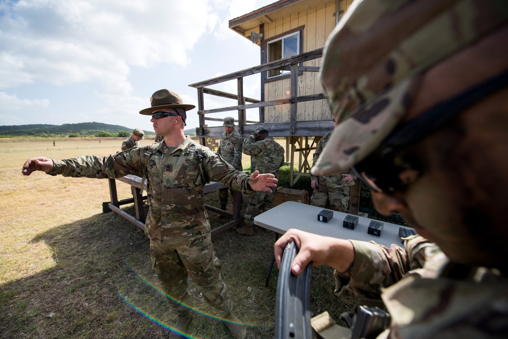 U.S. Army Sgt. 1st Class William Hale (left), Company F, 232nd Medical Battalion range safety officer, from Joint Base San Antonio-Fort Sam Houston, hands out ammunition for the M4 stress shoot event during the Army Drill Sergeant of the Year Competition Aug. 20 at JBSA-Camp Bullis.