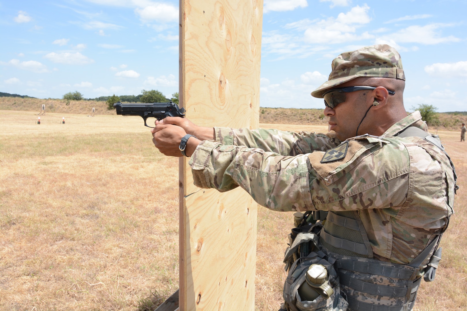 Staff Sgt. Jeffrey C. Lullen, Health Readiness Center of Excellence at Joint Base San Antonio-Fort Sam Houston, firing an M9 at the mystery event. In this lane while firing from the standing, kneeling, and prone positions the competitors first fired the M4 rifle then transitioned to the M4 pistol.