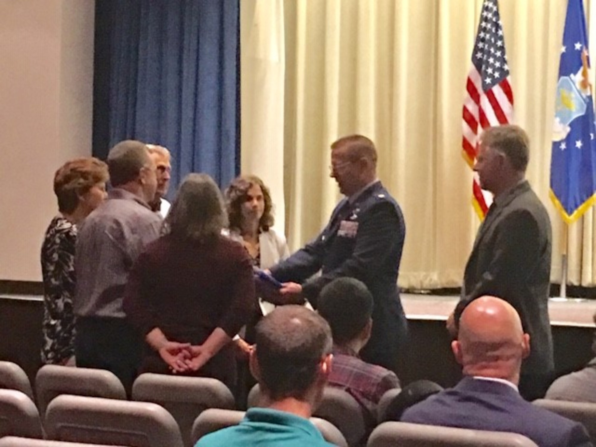Maj. Thomas Wingard, F-135 supply chain manager for the Defense Contracting Management Agency, presents a certificate and photo of the Memorial to the family of Lt. Lacy, who died in a vehicle accident. (U.S. Air Force photo/Kimberly Gaither)
