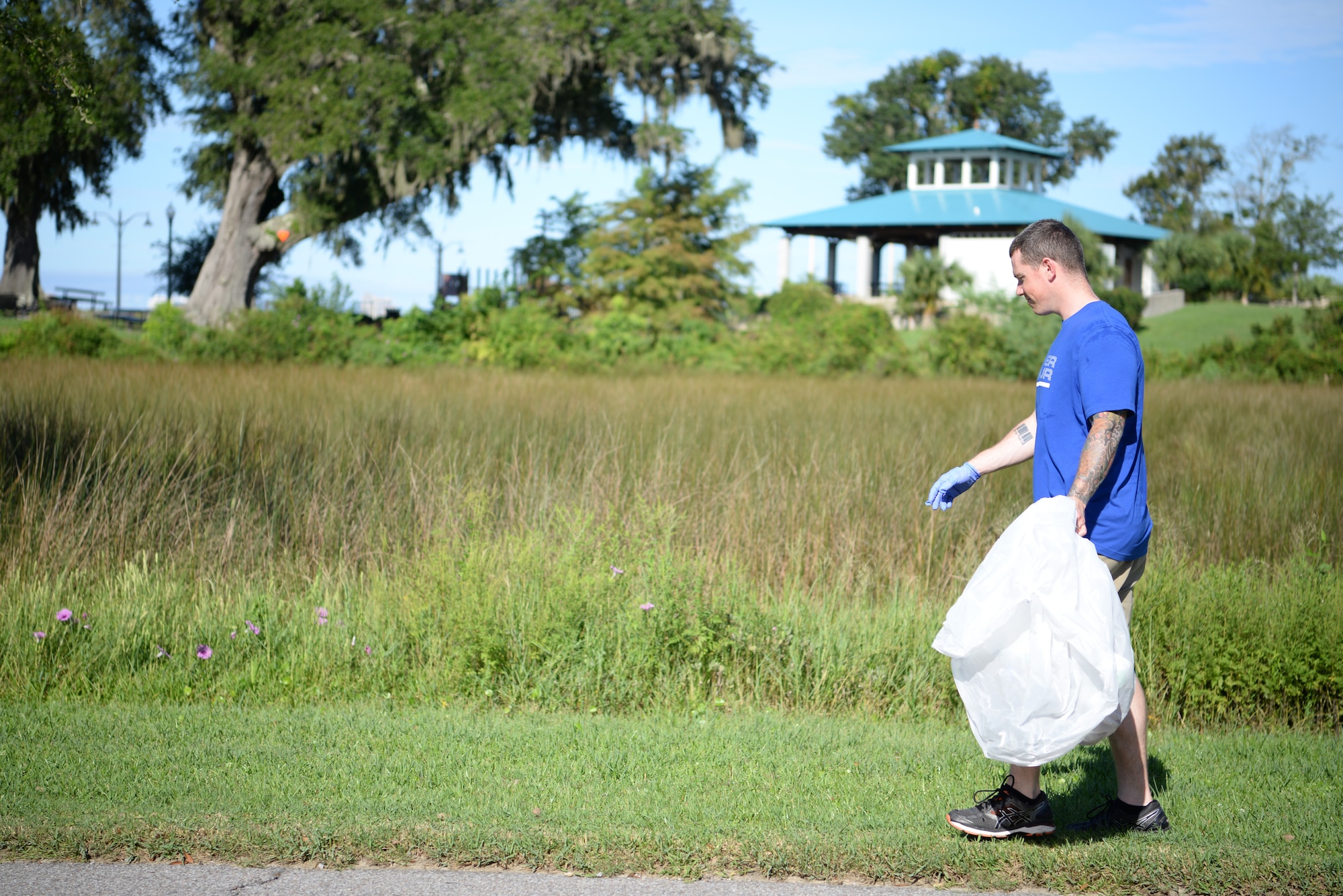 U.S Air Force Tech. Sgt. Sam Collings, Mathies NCO Academy student, looks for trash during the Community Clean-Up Day in Ocean Springs, Mississippi, Aug. 24, 2019. Volunteers coming from Ocean Springs and Keesler Air Force Base took to the streets of Ocean Springs to pick up trash around the city. (U.S Air Force photo by Airman 1st Class Spencer Tobler)