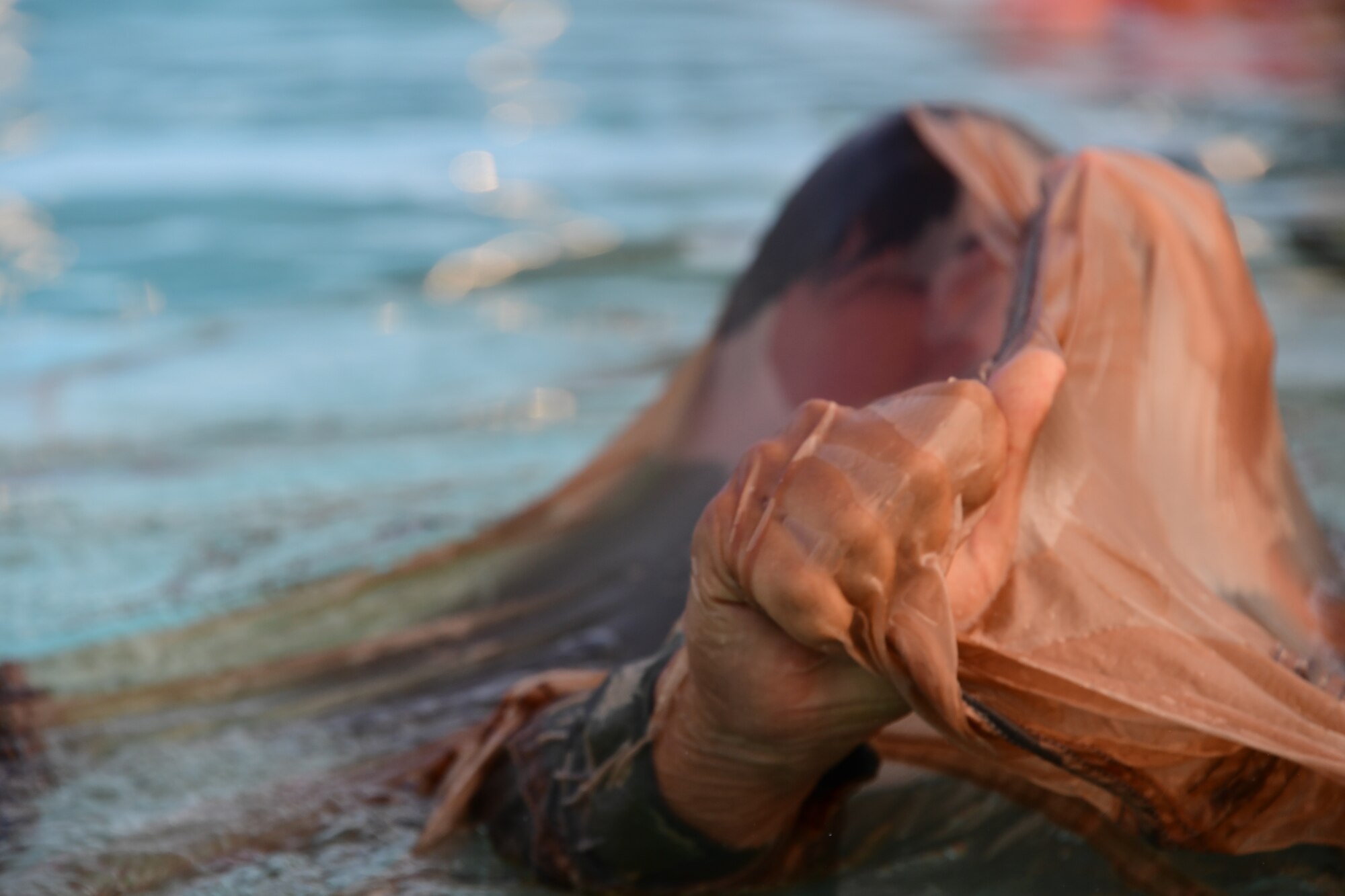 A member of the 758th Airlift squadron swims under a parachute for disentanglement training at Settler’s Cabin Park in Pittsburgh, Pennsylvania, August 3, 2019. The Airmen of the 758th Airlift squadron and the 911th Aeromedical Staging Squadron must train with the C-17’s Globemaster III aircraft safety equipment every three years.
