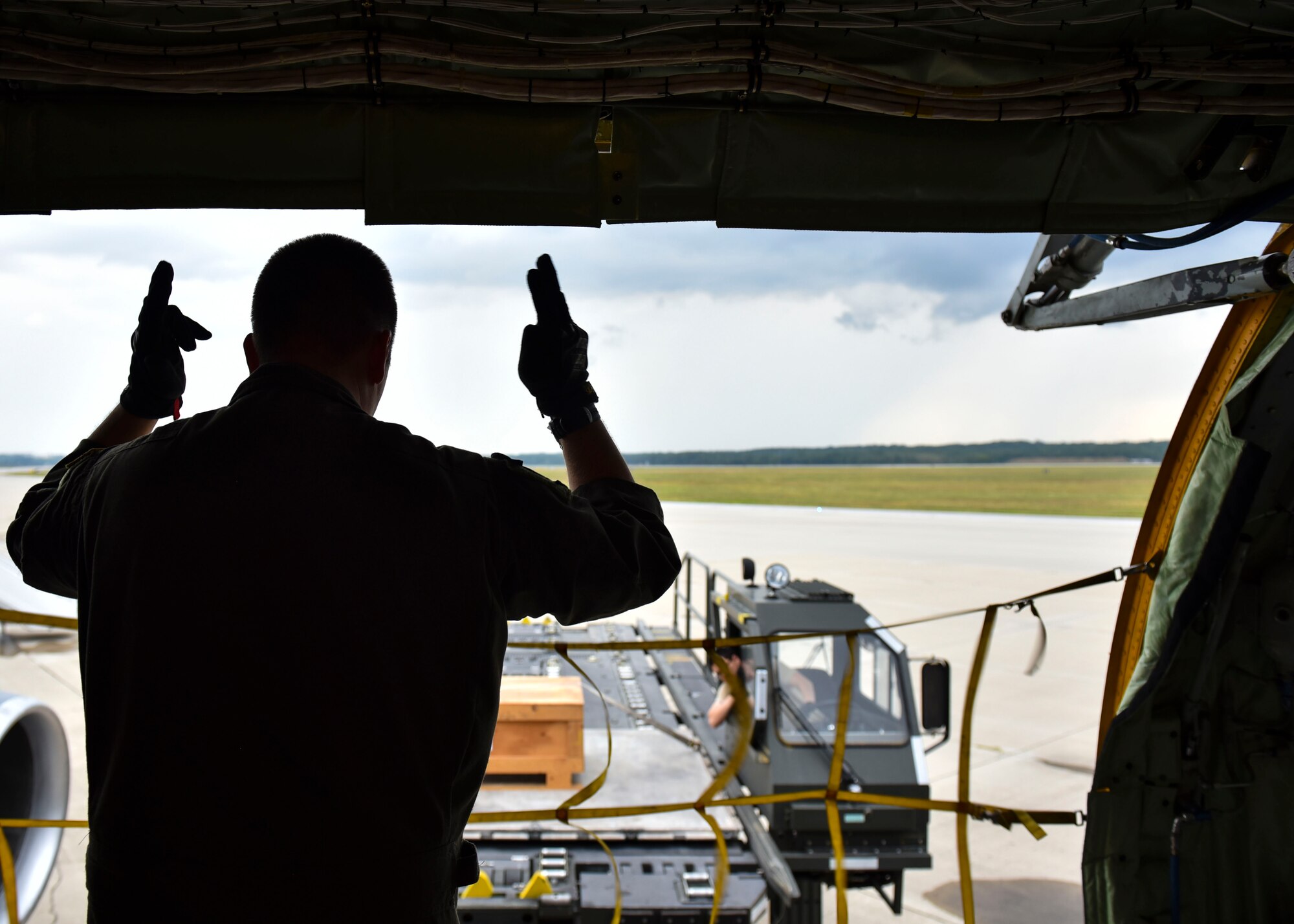 U.S. Air Force Master Sgt, Joseph Ekker signals to Kevin Shaffer, Data Monitor Systems material handler