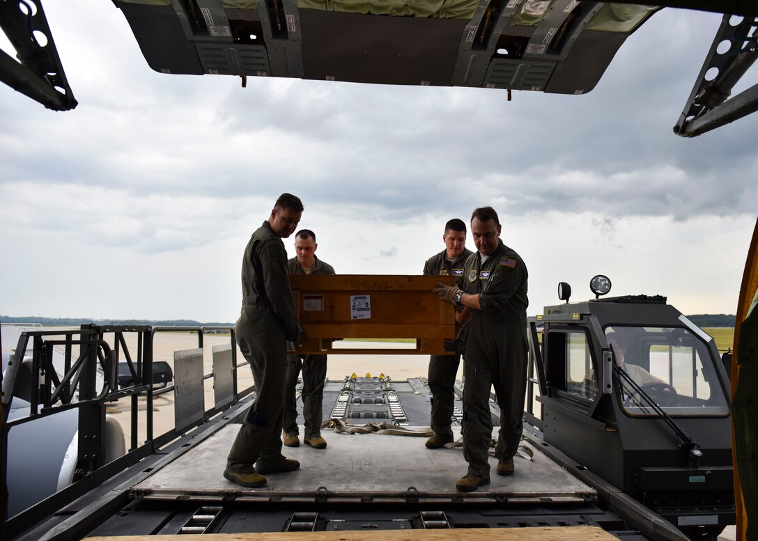 U.S. Air Force Airmen from the 97th Air Refueling Squadron move a box of memorabilia onto a KC-135 Stratotanker