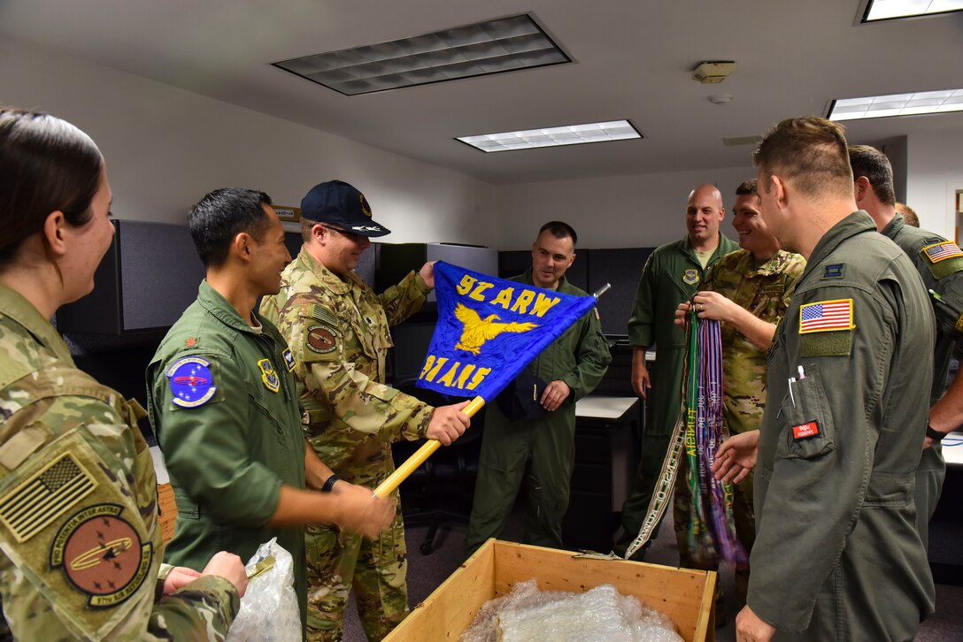 U.S. Air Force Airmen from the 97th Air Refueling Squadron unbox a guidon from their memorabilia box